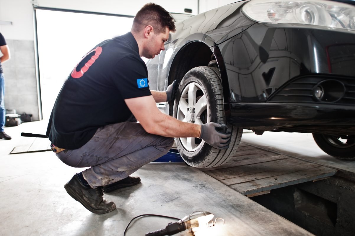 car repair maintenance theme mechanic uniform working auto service checking tyres 1202x800 1